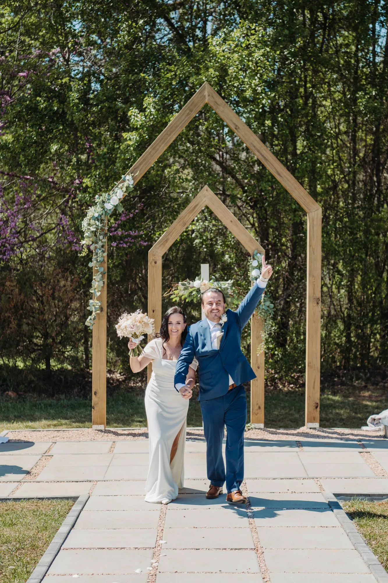Newlyweds celebrating as they walk back up the aisle at The Heritage Barn