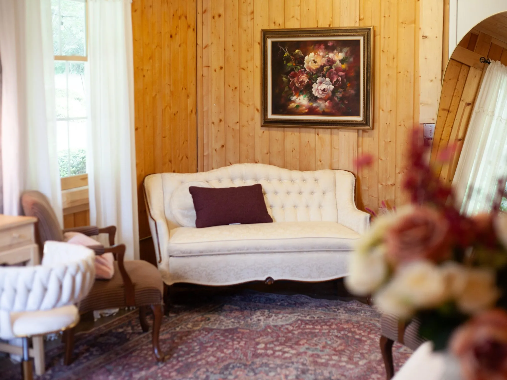 Bridal suite with a tufted settee and wood-paneled walls at The Heritage Barn